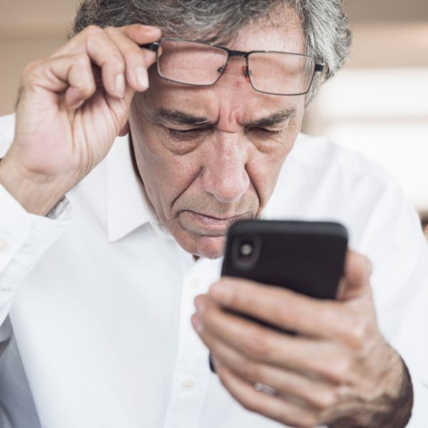 close up serious senior man looking smart phone scaled 062f471b