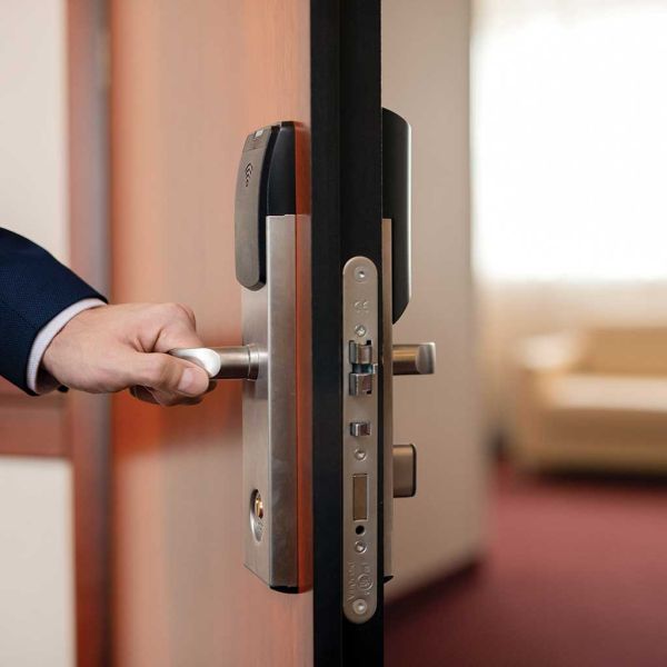 human hand holding handle wooden door while entering one hotel room arrival city during business travel 3e0c50ec